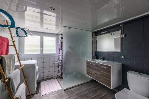 een badkamer met een douche, een wastafel en een toilet bij Superbes appartements in Mimizan