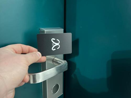 a hand holding a door handle with a symbol on it at Mickitos Urban Hostel in Skopje