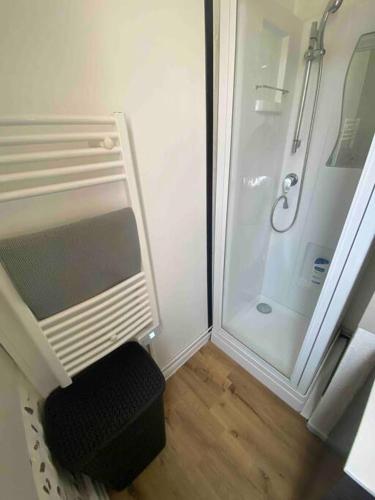 a bathroom with a shower and a black stool at Laurema's BnB in Toulouse