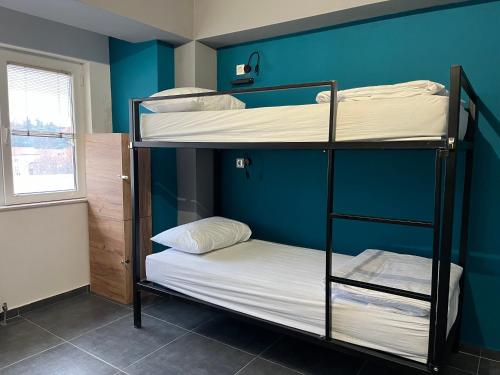 two bunk beds in a room with a blue wall at Mickitos Urban Hostel in Skopje