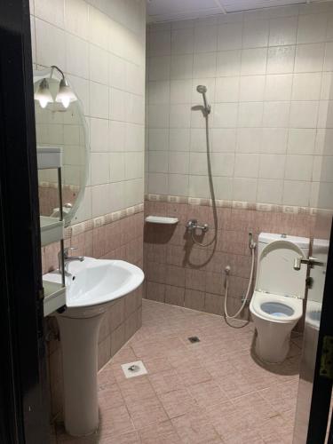 a bathroom with a shower and a toilet and a sink at Ramble Stay Hostel in Dubai