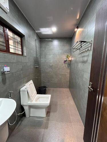 een badkamer met een toilet en een wastafel bij Puthenveettil in Kottayam