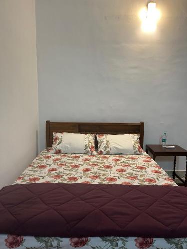 a bedroom with a bed with a bedspread and pillows at Puthenveettil in Kottayam