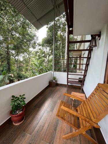 een balkon met een houten bank en een trap bij Puthenveettil in Kottayam