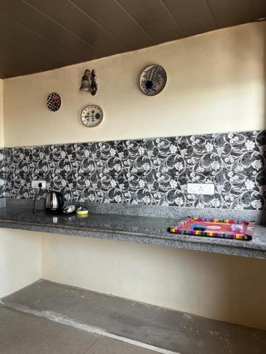 a kitchen counter with plates on the wall at EcoEscape Mukteshwar in Mukteswar
