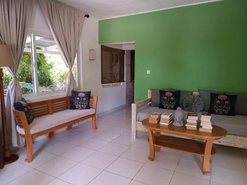 a living room with a couch and a table at Lucy's guesthouse in La Digue