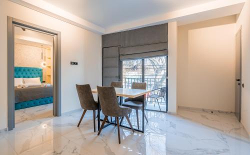 a dining room with a table and chairs and a bed at Luxury X By Umbrella in Tbilisi City