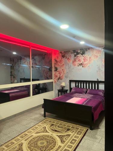 ein Schlafzimmer mit einem Bett mit lila Bettwäsche und Blumen in der Unterkunft ابراج المسارات in Dschidda