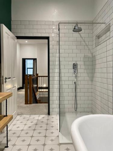 a bathroom with a shower and a bath tub at Capel Salem by Birch Stays in Blaenau-Ffestiniog