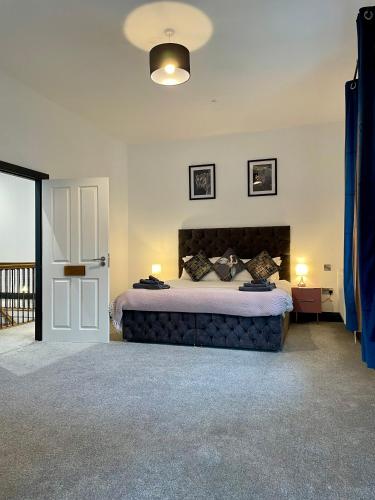 a bedroom with a large bed and a sliding door at Capel Salem by Birch Stays in Blaenau-Ffestiniog