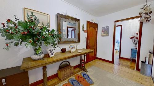 Habitación con mesa, espejo y planta en Casa del Mar, en Santoña