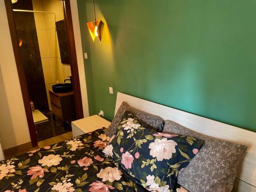 een slaapkamer met een bed met een bloemenbed en kussens bij Airport Accommodation Deluxe Bedroom and Private Bathroom near Airport Self Check In and Self Check Out in Mqabba