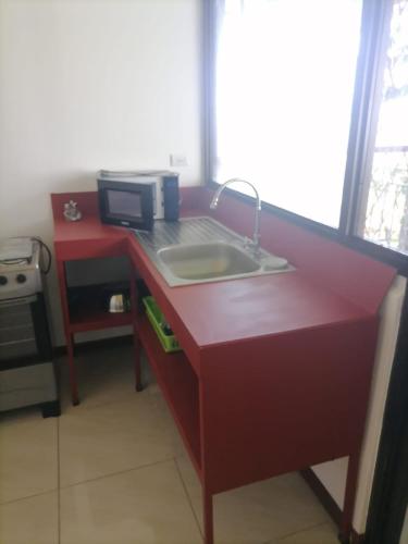 a kitchen counter with a sink and a microwave at Villa Garita Inn in La Garita