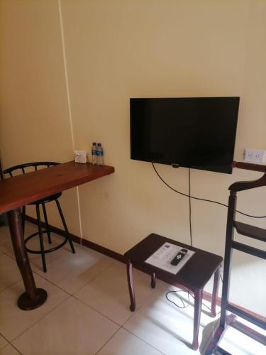a living room with a tv and a table and a chair at Villa Garita Inn in La Garita