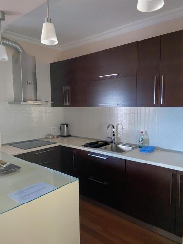 a kitchen with dark brown cabinets and a sink at Mollys2apartment in Pogradec
