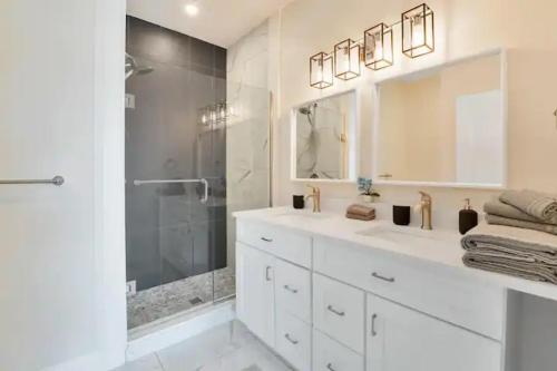 a white bathroom with a shower and a sink at New Walkerville Cozy Brownstones in Windsor