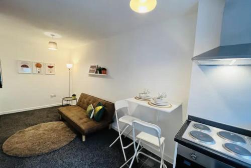 a living room with a table and a couch and a stove at Minimalist 1Bed Apt near City Centre in Liverpool