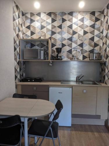 une cuisine avec une table, un évier et un comptoir dans l'établissement Appartement et salle de jeu, à Saint-Claude