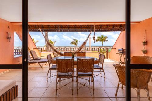 uma sala de jantar com uma mesa e cadeiras numa varanda em Oceanview A102 - PÉ NA ÁREA - perto do centro, 2 dormitórios, piscina, cozinha, 116m2 em Cumbuco