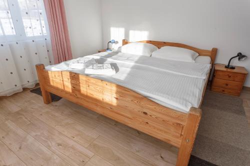 a large wooden bed with white sheets and pillows at Casa De Vacanta Armi in Molidu