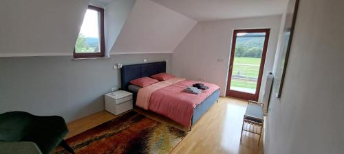 een slaapkamer met een bed en een groot raam bij Hisa Haasberg in Planina
