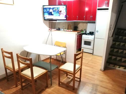 una cocina con mesa y sillas y una cocina con armarios rojos. en Roses, Puig Rom, en Roses