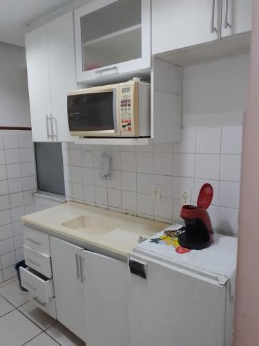 una cocina con microondas y una silla roja en la encimera en Porto maravilha, en Río de Janeiro