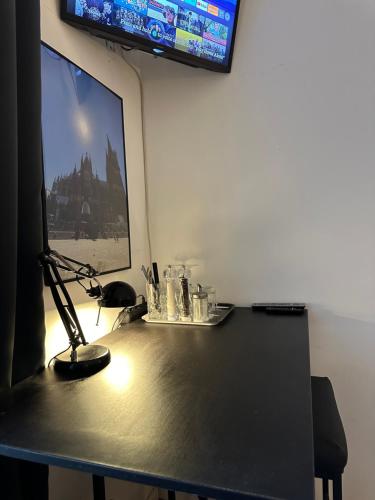a desk with a television and a lamp on it at urban-studios-cologne I studio in Cologne