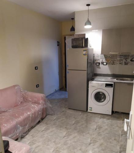 a kitchen with a refrigerator and a washing machine at zooz home vacation in El Alamein