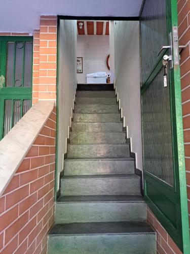 a stairway leading up to a building with a green door at Casa Costa Verde-Muriqui in Vila Muriqui