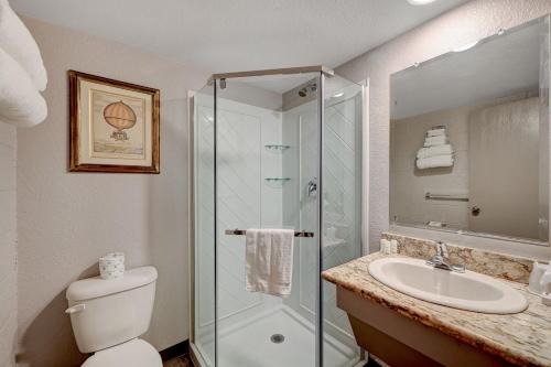 a bathroom with a shower and a toilet and a sink at Bridger Inn Hotel Downtown in Las Vegas