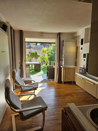 Il comprend un salon avec deux chaises et une cuisine. dans l'établissement Studio MANON A2, aux Lecques