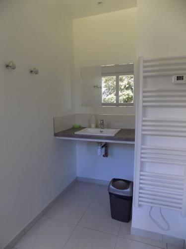 a white bathroom with a sink and a window at Gite de Pellein in Quéménéven