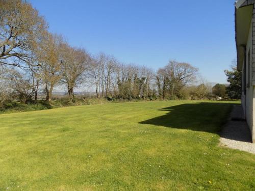 a large field of green grass with trees in the background at Gite de Pellein in Quéménéven