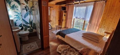 a bedroom with a bed and a bathroom with a window at Casa Bunicii in Costeşti