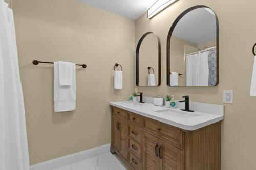 La salle de bains est pourvue d'un lavabo et d'un miroir. dans l'établissement Chic 4-Bed Home near Attractions - JZ Vacation Rentals, à Soulard
