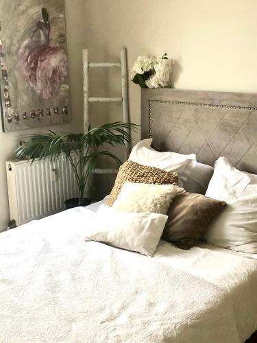 un lit avec des draps blancs et des oreillers dans une chambre dans l'établissement Apartment Trocadero/Eiffel Tower, à Paris