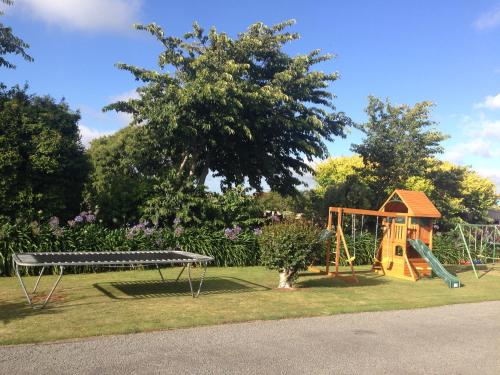 a park with a playground with a swing at Mount View Motel Hawera in Hawera