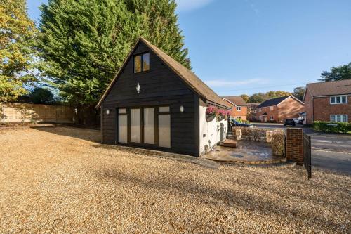 a house with a garage on a gravel driveway at Romantic getaway UK with Private Sauna, King Bed, WiFi 517mbps & EV Charger in Woking