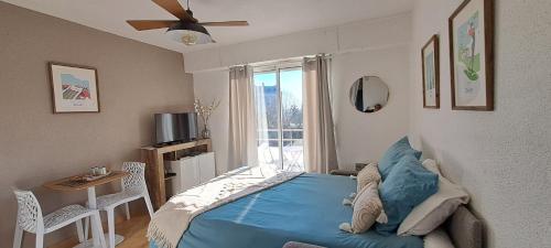 Un dormitorio con una cama azul y una ventana. en Darmaillacq Studio avec Balcon, parking, Netflix, en Cholet