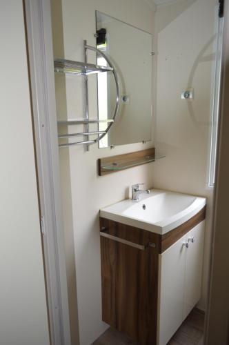 uma casa de banho com um lavatório e um espelho em mobil home em Sainte-Reine-de-Bretagne