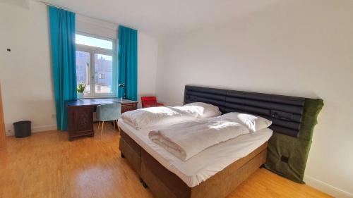 a bedroom with two beds and a desk and a window at Helles Zimmer mit Kingsize-Bett in Mannheim