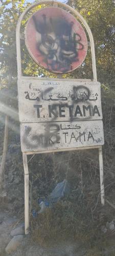 un cartel con graffiti en la parte de atrás. en Tlata ketama, en Tlata Ketama