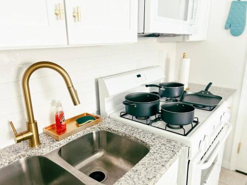 - un comptoir de cuisine avec 3 casseroles sur une cuisinière dans l'établissement Colorful Relaxation Luxe Family Stay - Extended Stay, à El Paso