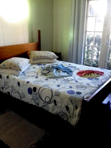 a bed with a comforter on it in a bedroom at Muqui 91 Guesthouse in Teresópolis