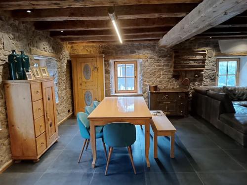 een eetkamer met een houten tafel en blauwe stoelen bij Brand new duplex in the Dolomites - Lupo Bianco in Rocca Pietore