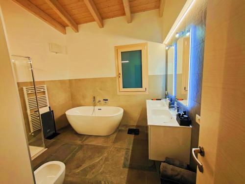 a bathroom with two sinks and a large white tub at Villa al Feudo in Brenzone sul Garda