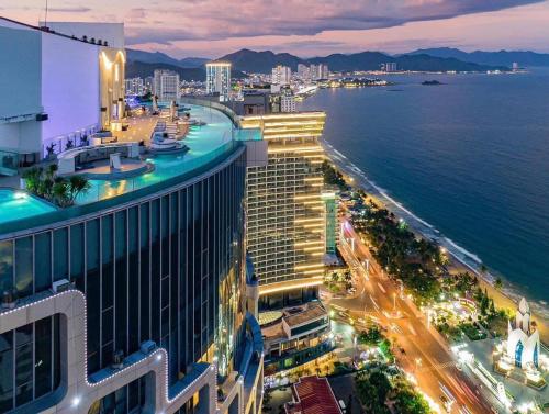 a view of a city at night with the ocean at OCEANFRONT PANORAMA RESIDENCE in Nha Trang