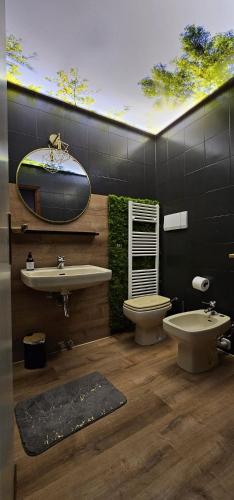 a bathroom with a sink and a toilet and a mirror at La Baita Residence 3.0 in Folgarida