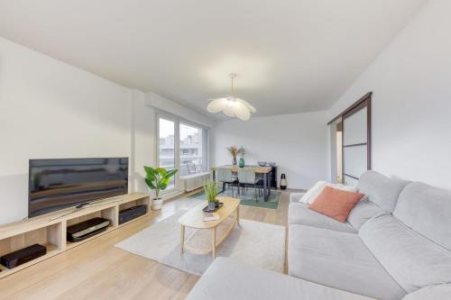 a living room with a couch and a tv at Grand appartement spacieux - Proche Paris in Sèvres